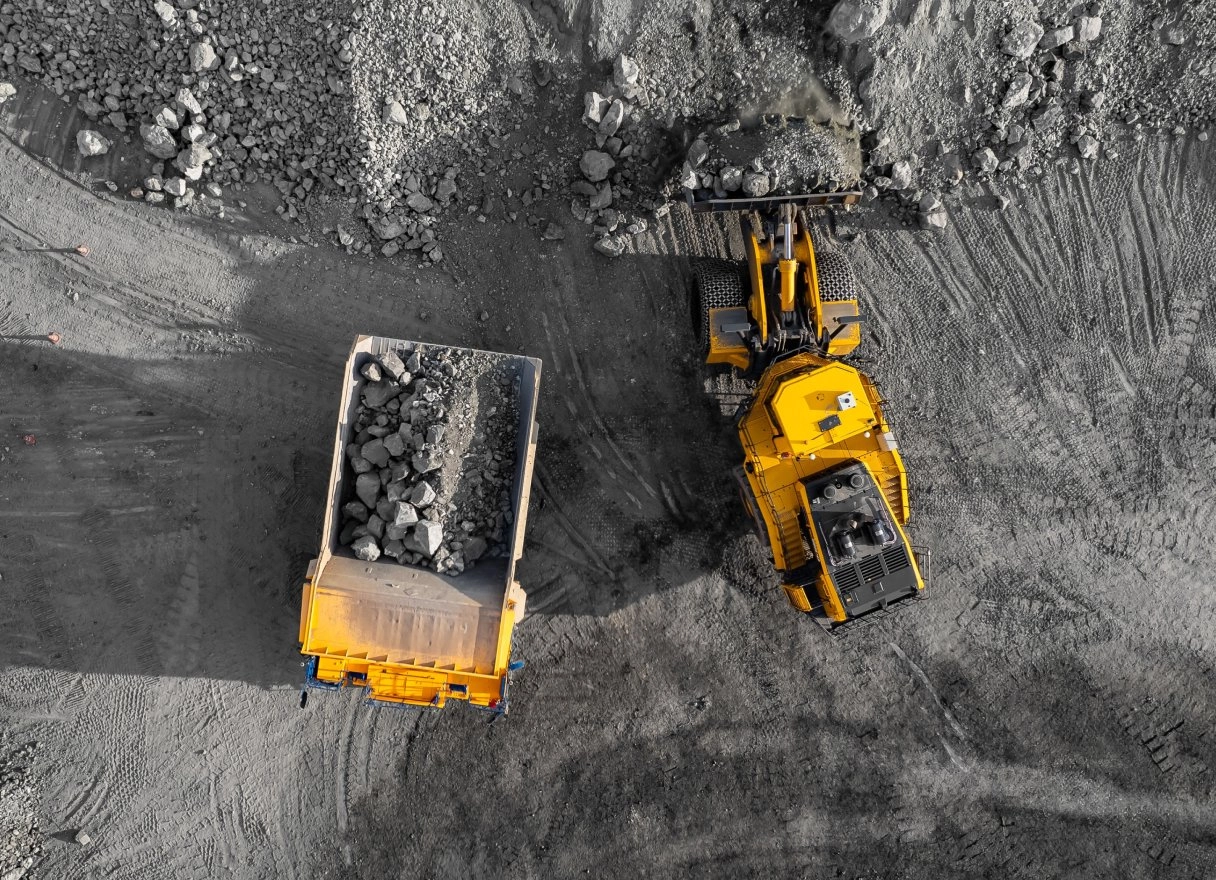 Aerial view of a loader filling a haul truck with ore at a mine